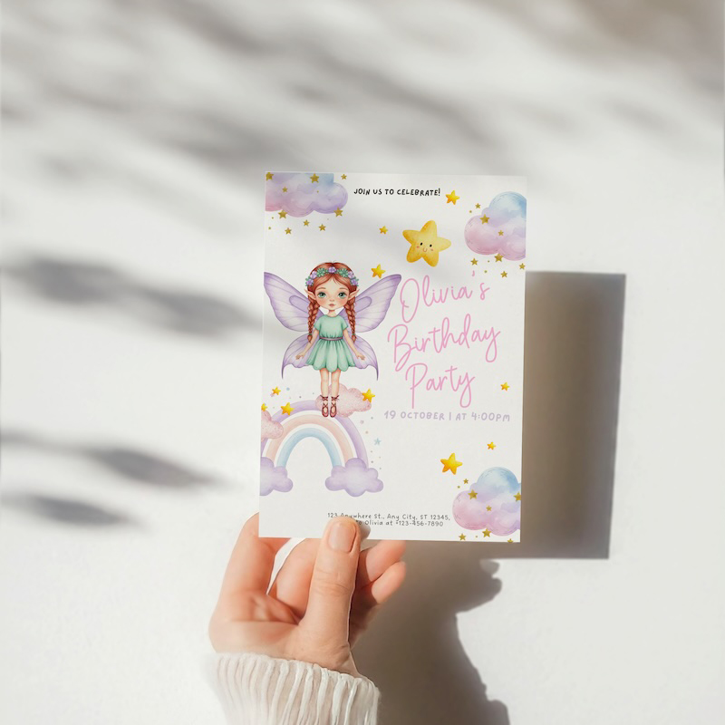 Party invite photographed by hand against a wall with a hard shadow