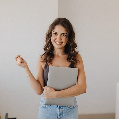 Diana smiling and holding her laptop