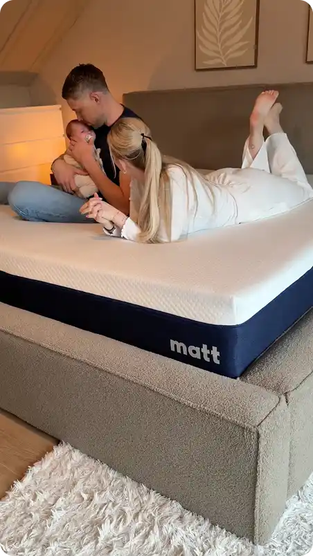 Family relaxing on mattress in cozy bedroom