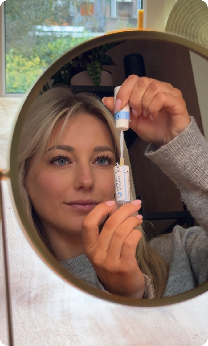 Nomige creator showing a skincare serum in front of a mirror