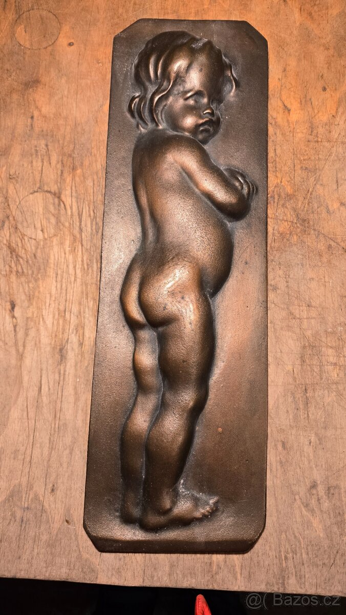Bronzový reliéf dítěte