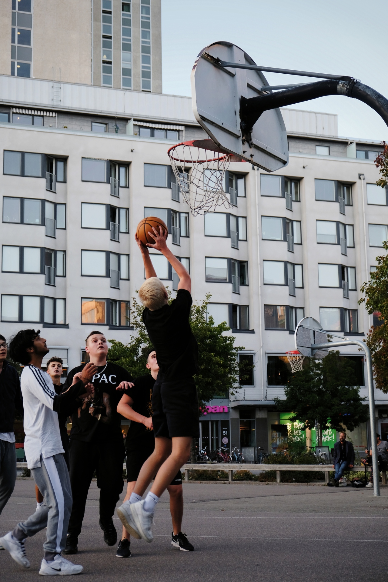 A few teens playing basketball on the island Södermalm in Stockholm.