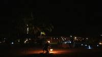 Bora Bora, slow motion shot of fire dancer on white sand by night