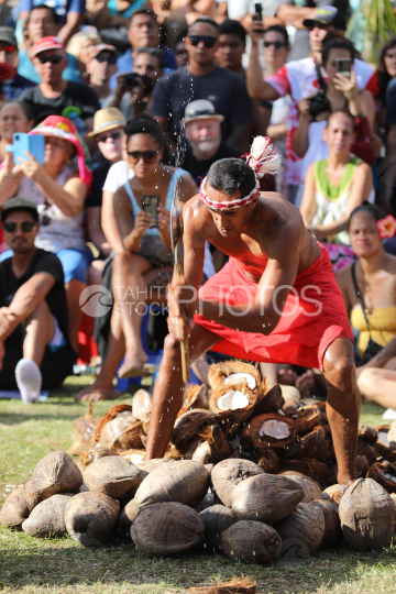 Tahiti, Polynesian man breaking coconuts with an ax, Tuaro Maohi Traditional Competition, Polynesia