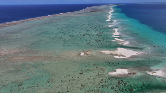 Aerial drone view of barrier reef and islets between lagoon and ocean, Polynesia, 4K UHD