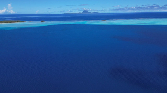 Bora Bora view from Tahaa, Drone Aerial Shot of Tahaa Lagoon with Mount Otemanu,Bora Bora, on the horizon, French Polynesia