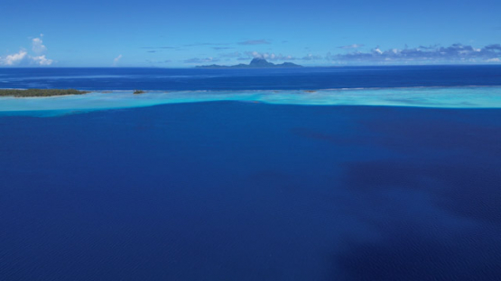 Bora Bora view from Tahaa, Drone Aerial Shot of Tahaa Lagoon with Mount Otemanu,Bora Bora, on the horizon, French Polynesia