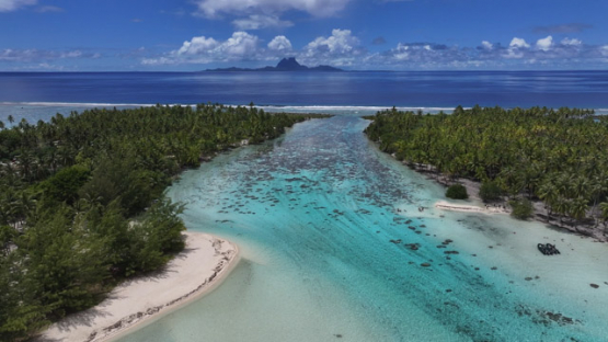 Bora Bora view from Tahaa, Drone Aerial Shot of Tahaa Lagoon with Mount Otemanu,Bora Bora, on the horizon, French Polynesia