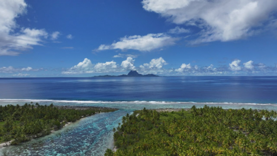 Bora Bora view from Tahaa, Drone Aerial Shot of Tahaa Lagoon with Mount Otemanu,Bora Bora, on the horizon, French Polynesia